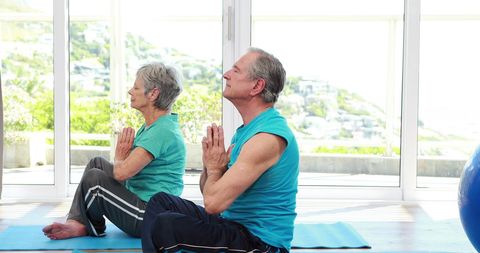 Elderly Couple Meditating Peacefully in Yoga Session at Home