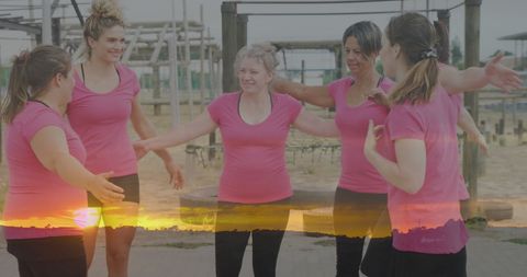 Unity and Fitness: Women Embracing at Obstacle Course at Sunset