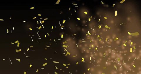 Glittering gold confetti drifting across dark bokeh background with warm metallic glow