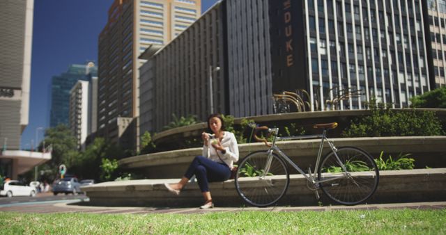 Urban professional taking break, checking smartphone, sitting by bicycle - Download Free Stock Images Pikwizard.com