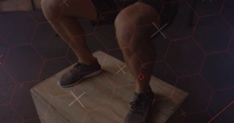 Athlete jumping off plyo box during explosive plyometric workout with hex grid overlay