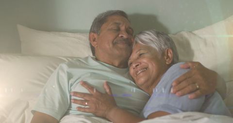 Warmth and Love: Happy Senior Couple Embracing in Bed