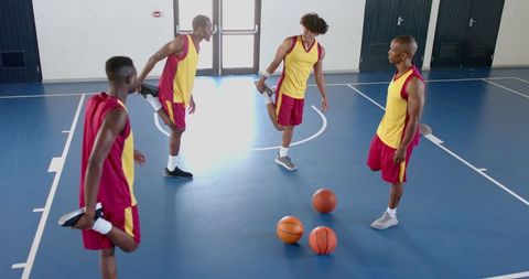Basketball Team Stretching Together Indoors for Improved Flexibility