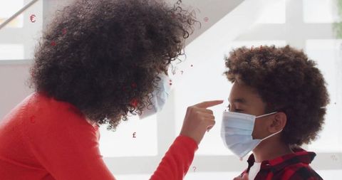 Mother Playfully Engaging with Son Wearing Masks Indoors