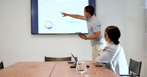 Diverse Professionals Discuss Project in Modern Office Conference Room