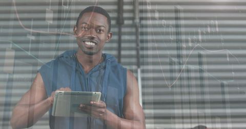 Athletic Man Analyzing Data on Digital Tablet at Modern Gym