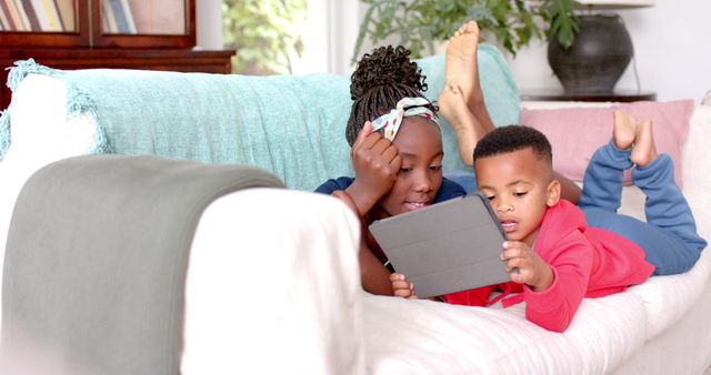 Children Siblings Lying on Couch Using Tablet for Learning - Download Free Stock Images Pikwizard.com