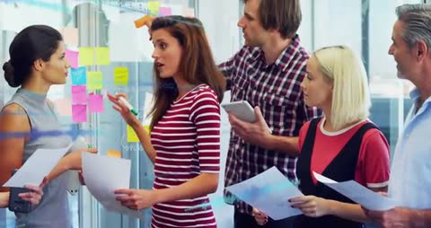 Diverse Team Brainstorming Ideas Using Sticky Notes in Modern Office