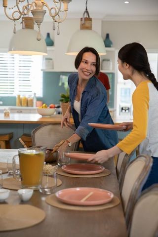 Family preparing dining table in cozy kitchen