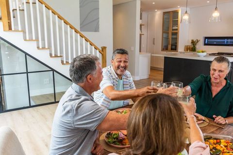 Senior Friends Toasting at Home Celebration Meal
