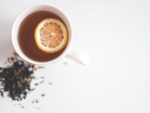 Top View of Mug with Herbal Tea and Lemon Slice on White Background