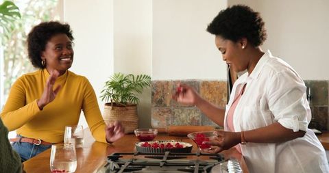 African american women preparing berry tart in bright kitchen