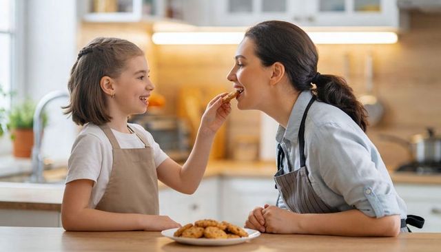 Daughter Feeding Mother Homemade Cookies at Cozy Kitchen Island Family Baking Moment