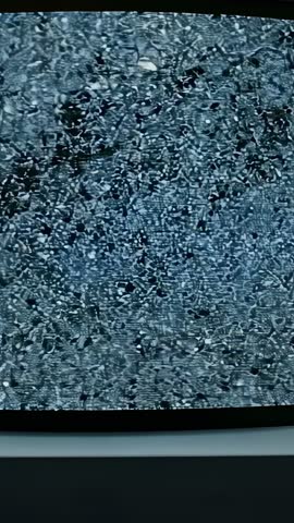 Camera Zooming into CRT Screen Revealing Monochrome Static Grain and Bluish Scanlines