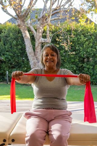 Senior African American Woman Using Red Resistance Band Outdoors