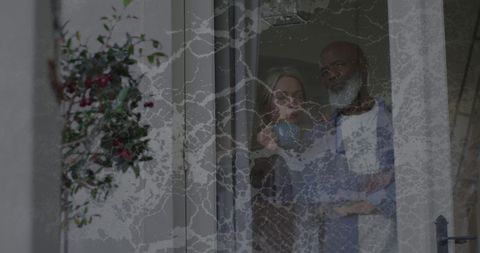 Senior diverse couple in deep thought near glass door