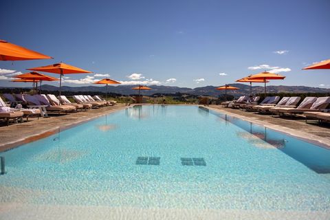 Luxury Resort Infinity Pool with Orange Umbrellas and Lounge Chairs