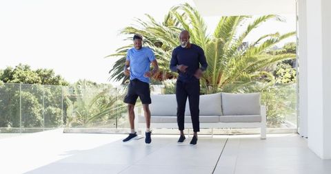 African American Father and Son Exercising on Sunlit Terrace
