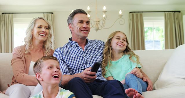 Happy Family Watching TV Together on Sofa in Living Room - Download Free Stock Images Pikwizard.com