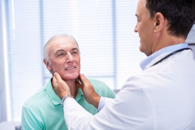 Doctor examining senior patient's neck in a clinic. Useful for healthcare, medical consultation, elderly care, and professional medical services. Ideal for articles, brochures, and websites related to senior health, medical checkups, and patient care.