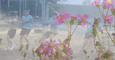 Children engaging in enthusiastic tug-of-war outdoors