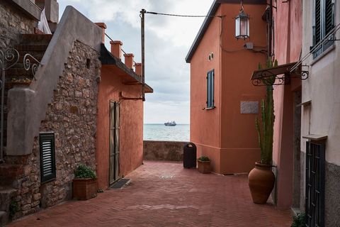 Mediterranean alley leading to sea, terracotta houses, stone staircase, distant ship