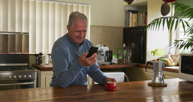 Senior Man Enjoying Morning Coffee in Kitchen While Using Smartphone - Download Free Stock Images Pikwizard.com