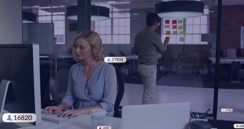 Businesswoman analyzing data in modern office with colleague