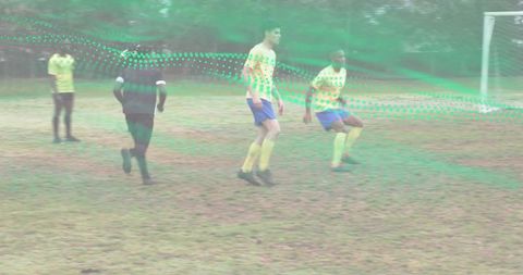 Amateur soccer players running on worn grass pitch with green motion overlay