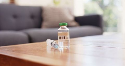Syringe and vial ready for injection in cozy living room