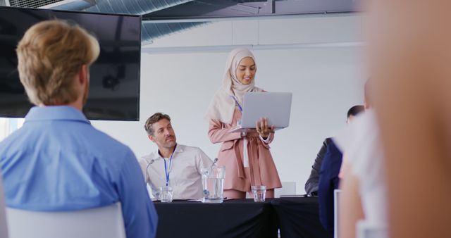 Hijabi Woman Presenting at Business Meeting in Modern Office - Download Free Stock Images Pikwizard.com