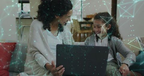 Mother and daughter sharing laptop and learning with global digital network overlay