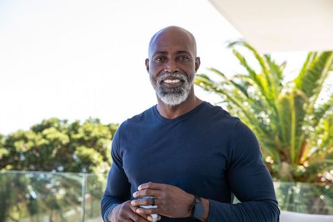 Casual African American Man Relaxing on Modern Terrace with Coffee