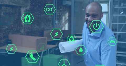 Smiling architect holding plans showing augmented reality sustainability icons in office