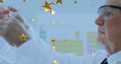 Senior scientist examining vial in laboratory with gold star confetti overlay