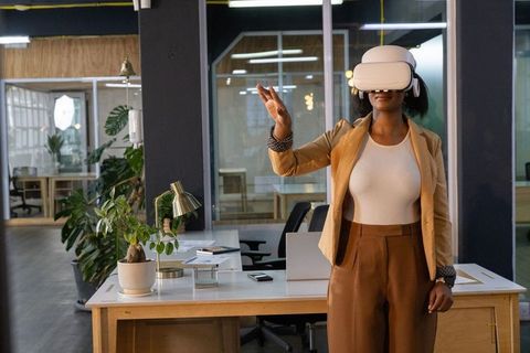 African american woman exploring virtual reality in modern coworking office with plants