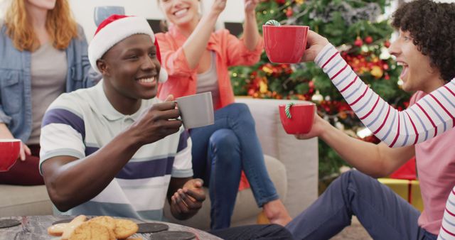 Happy group of diverse friends drinking cocoa. Spending quality time at home together at christmas.