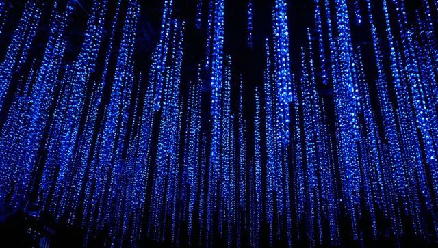Glowing blue led curtain installation cascading vertical light strands for neon ambience