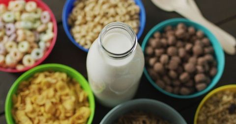 Colorful Cereal Bowls with Milk Bottle on Wooden Table - Download Free Stock Images Pikwizard.com
