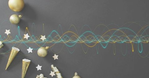 Scattering gold ornaments with teal and gold waveform on gray flat lay