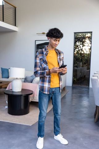 Young Man Using Smartphone in Modern Living Room