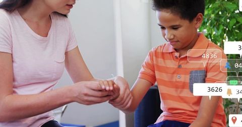 Caregiver checking boy wrist during pediatric clinic visit, comforting and assessing
