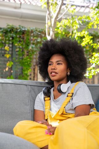 Young woman relaxing on garden patio with headphones