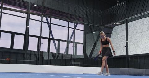 Fit Woman Preparing for Padel Game on Modern Indoor Court