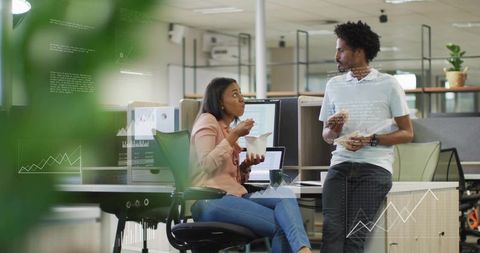 Coworkers taking lunch break in open-plan office with data overlays and casual chat