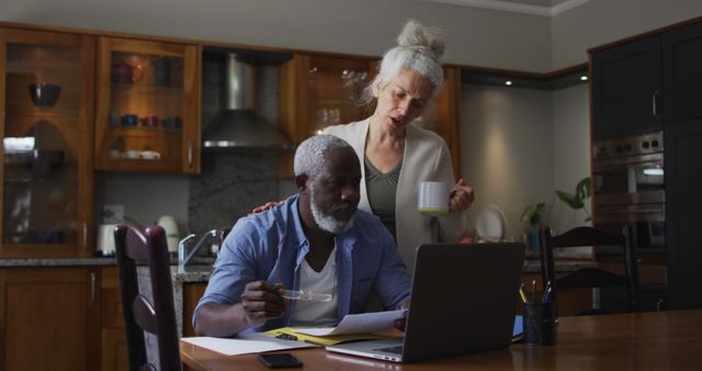 Biracial senior couple using laptop discussing and calculating finances at home. retirement senior couple lifestyle self isolation in quarantine lockdown