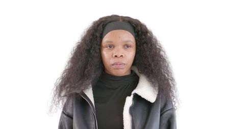 Confident woman in black jacket with curly hair looking determined