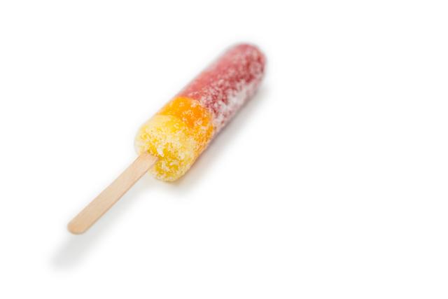 This image shows a close-up of a two-flavor popsicle with a frosty surface, isolated on a white background. Ideal for use in advertisements for summer treats, dessert menus, or promotional materials for ice cream brands. The vibrant colors and frosty texture highlight the refreshing nature of the popsicle, making it perfect for marketing campaigns focused on cooling down during hot weather.