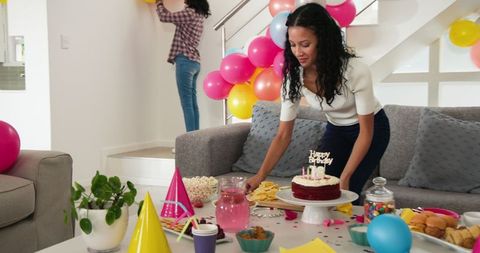 Mother and Daughter Decorating for Birthday Celebration with Balloons