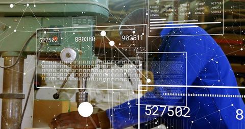 Technician operating drill press in high-tech manufacturing facility